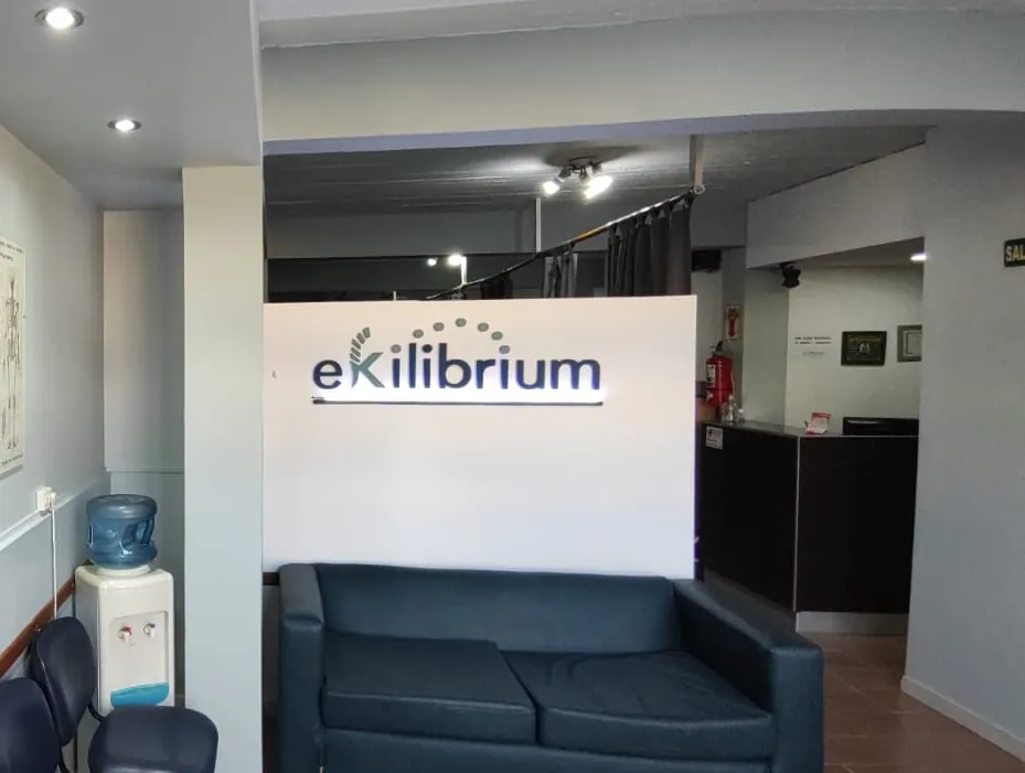 Sala de espera de Ekilibrium con el logo iluminado en la pared.